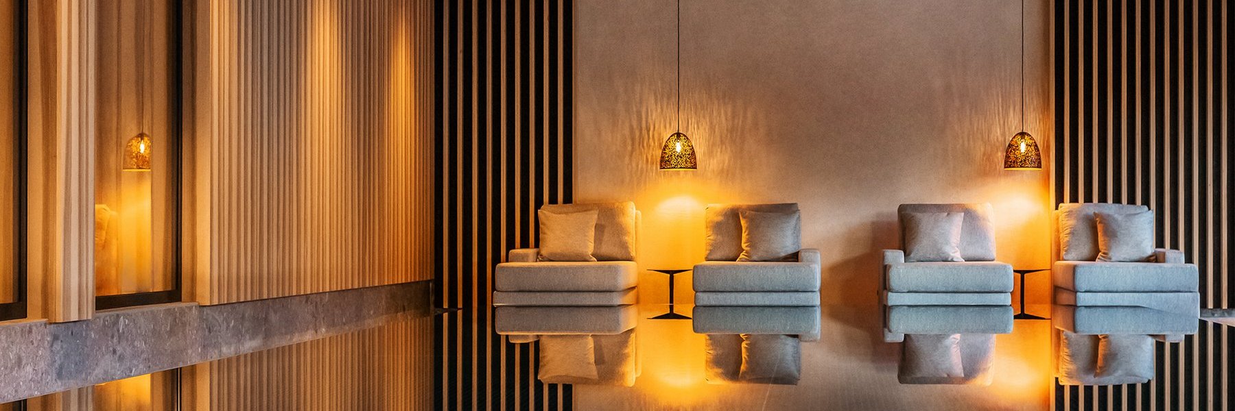 Moderner Wellnessbereich mit gemütlichen Kuschelliegen und Infinity Indoor Pool