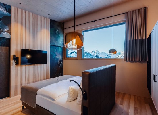 Suite Edelweiß im Panoramahotel Alpenstern in Damüls mit moderner Einrichtung und freistehendem Bett