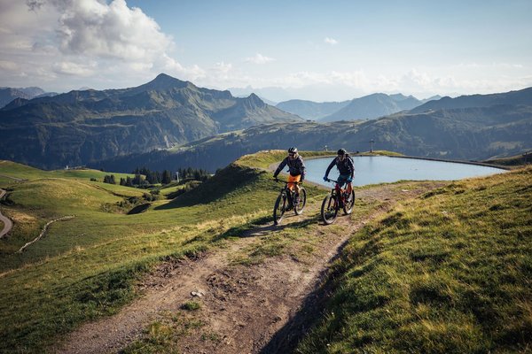 Fahrradfahrer beim Mountainbiken in den Bergen im Sommer mit Wolken am Himmel