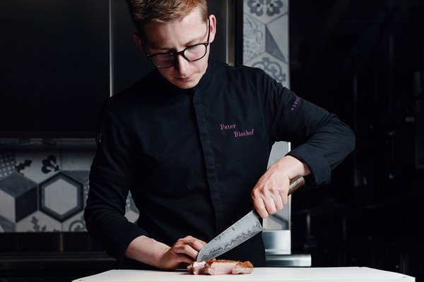 Koch Peter Bischof vom Panoramahotel Alpenstern schneidet Fleisch mit einem Chefmesser