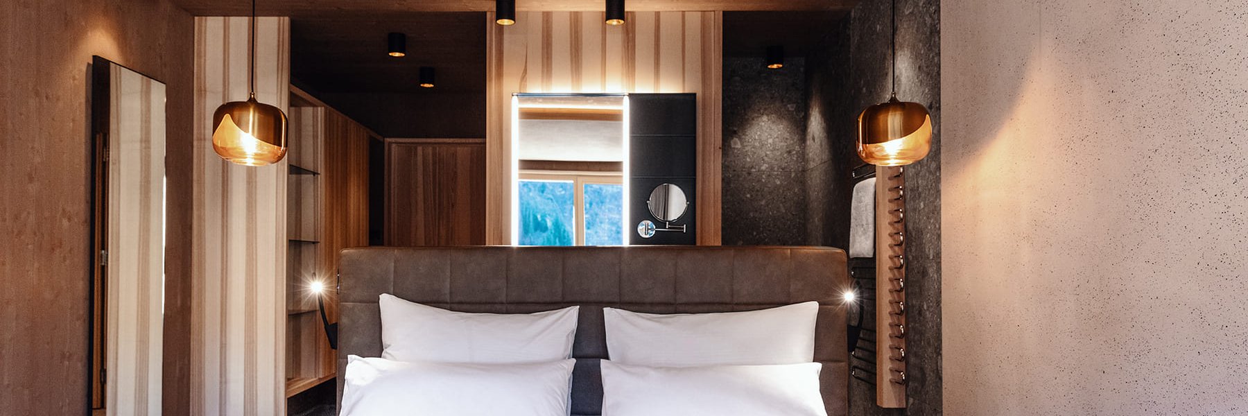 Freistehendes Bett in modern eingerichtetem Hotelzimmer mit offenem Bad