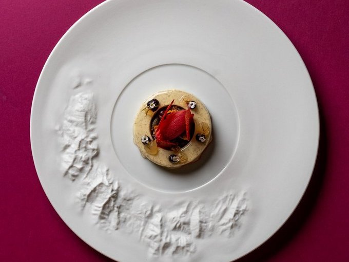 Kreatives Dessert auf strukturiertem Designer-Teller vor violettem Hintergrund