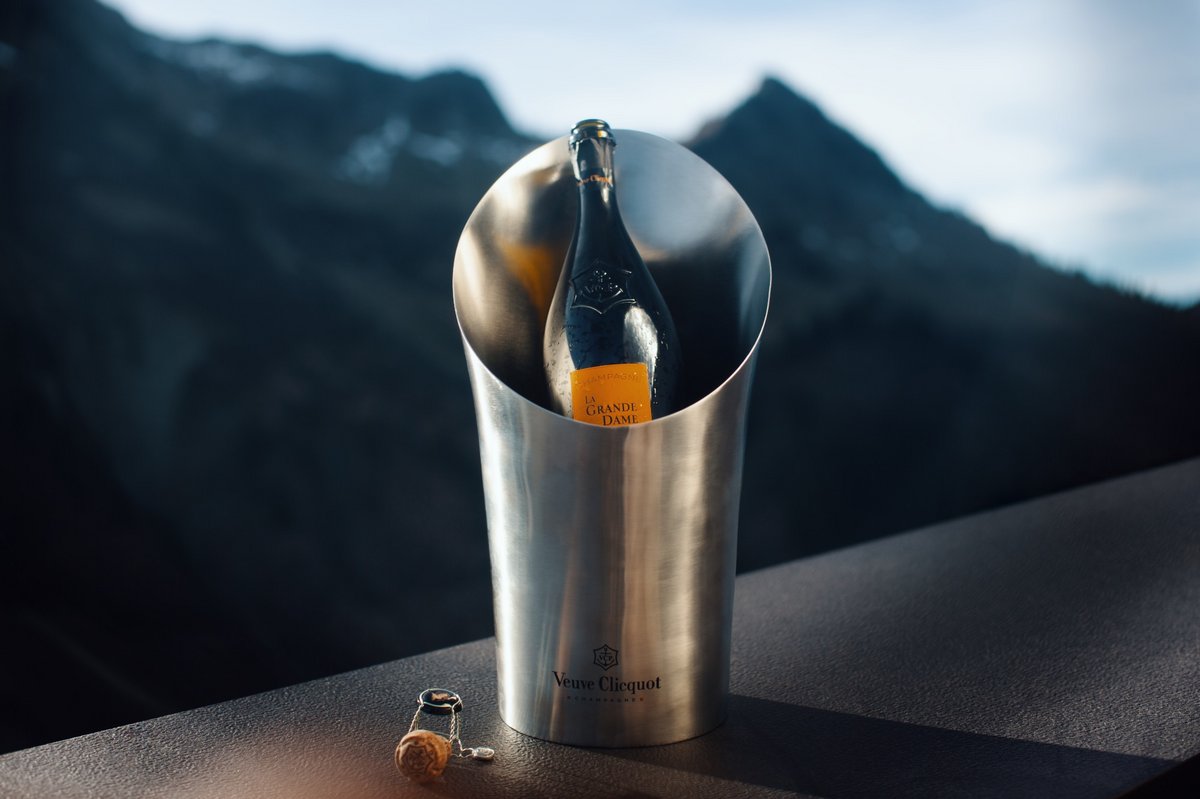Veuve Clicquot Champagner liegt geöffnet in einem Flaschenkühler vor einem Bergpanorama