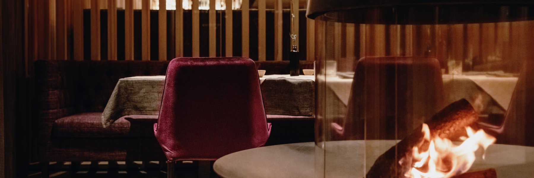 Offenes Kaminfeuer in einem modernen Restaurant mit gedeckten Tischen