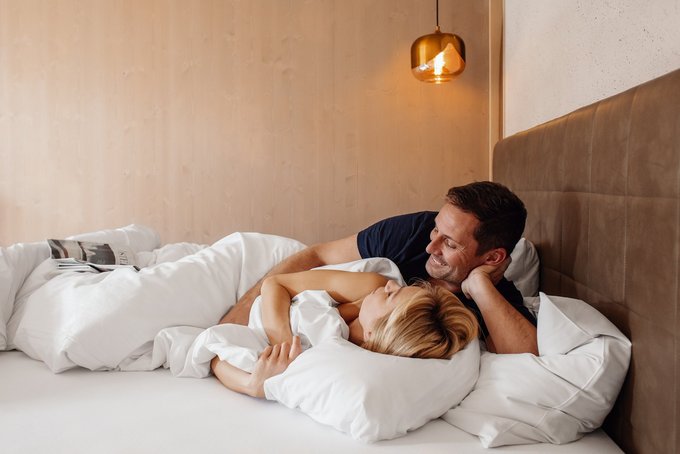 Mann und Frau beim Kuscheln im Doppelbett