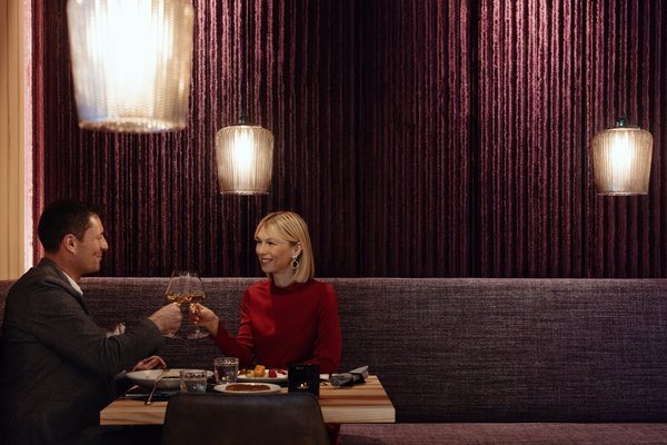 Pärchen sitzt in einem modernen Restaurant und trinken ein Glas Weißwein